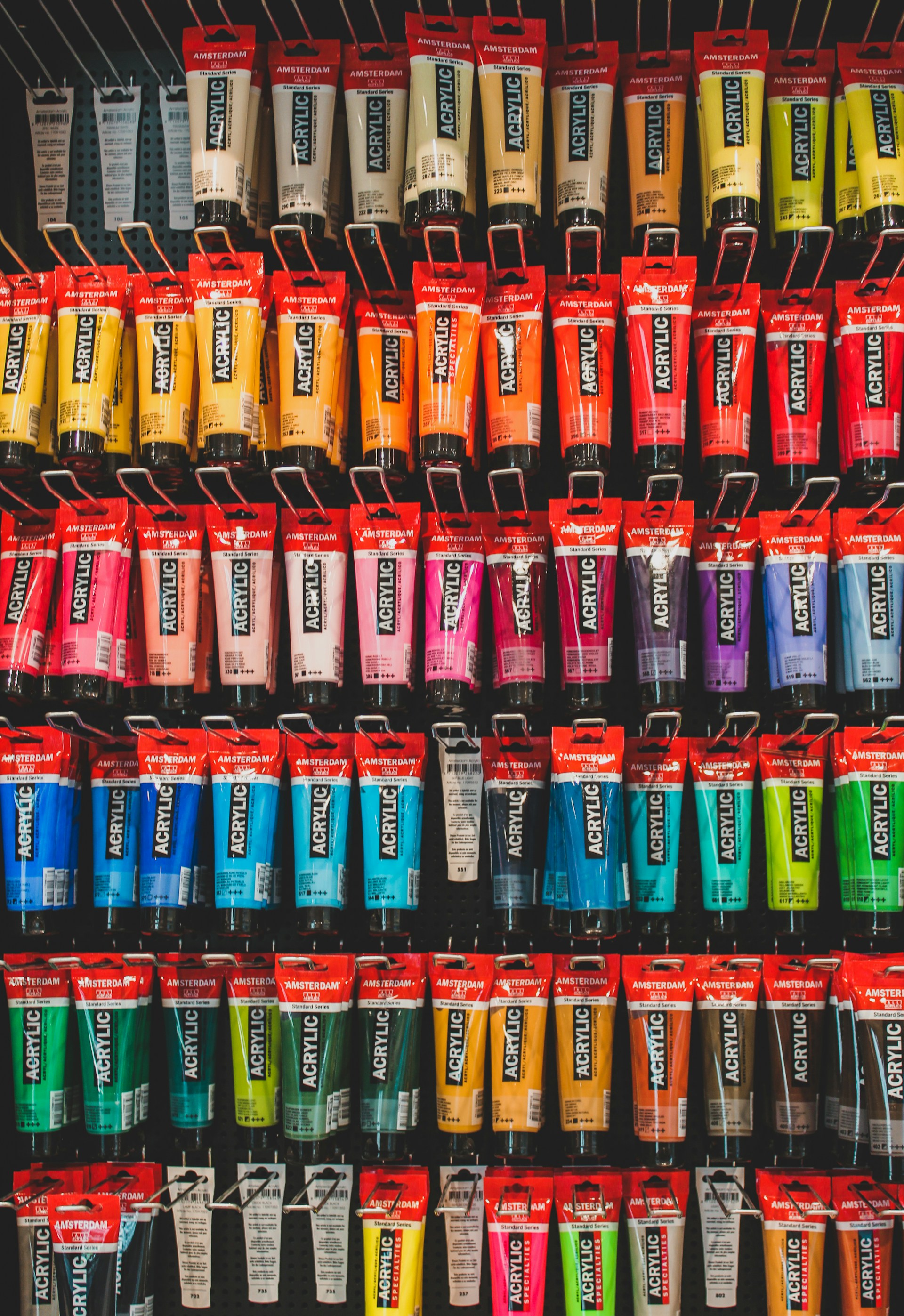 Rows of colorful acrylic paint tubes